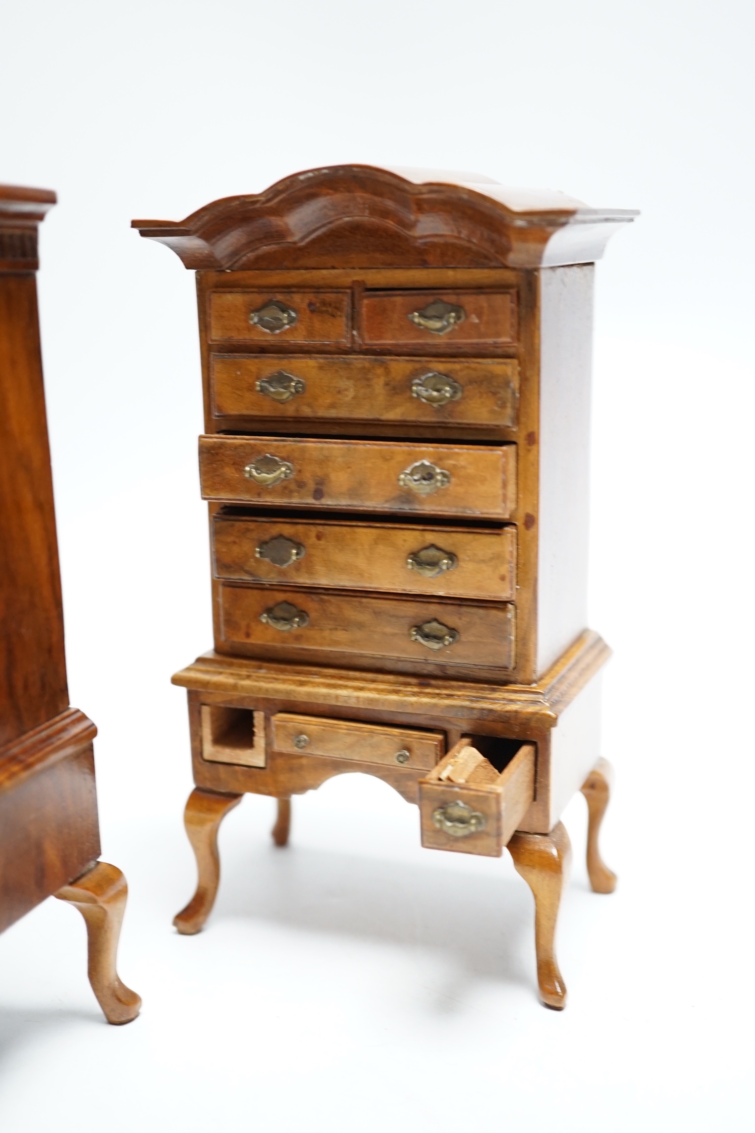 Two pieces of early 20th century miniature furniture - a mid-18th century style walnut bookcase, indistinctly signed on the base (15.5cm high) and a mid-18th century-style walnut chest on stand (16cm high). (Provenance B